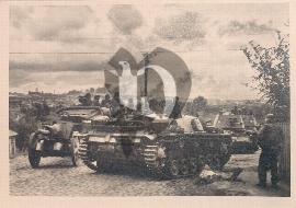 Recto carte postale ancienne vu sur Anvers en feu aprés une bataille voyant des soldats SS dans un tank STUG 3 d'autre dans des véhicules militaires transportant des canons